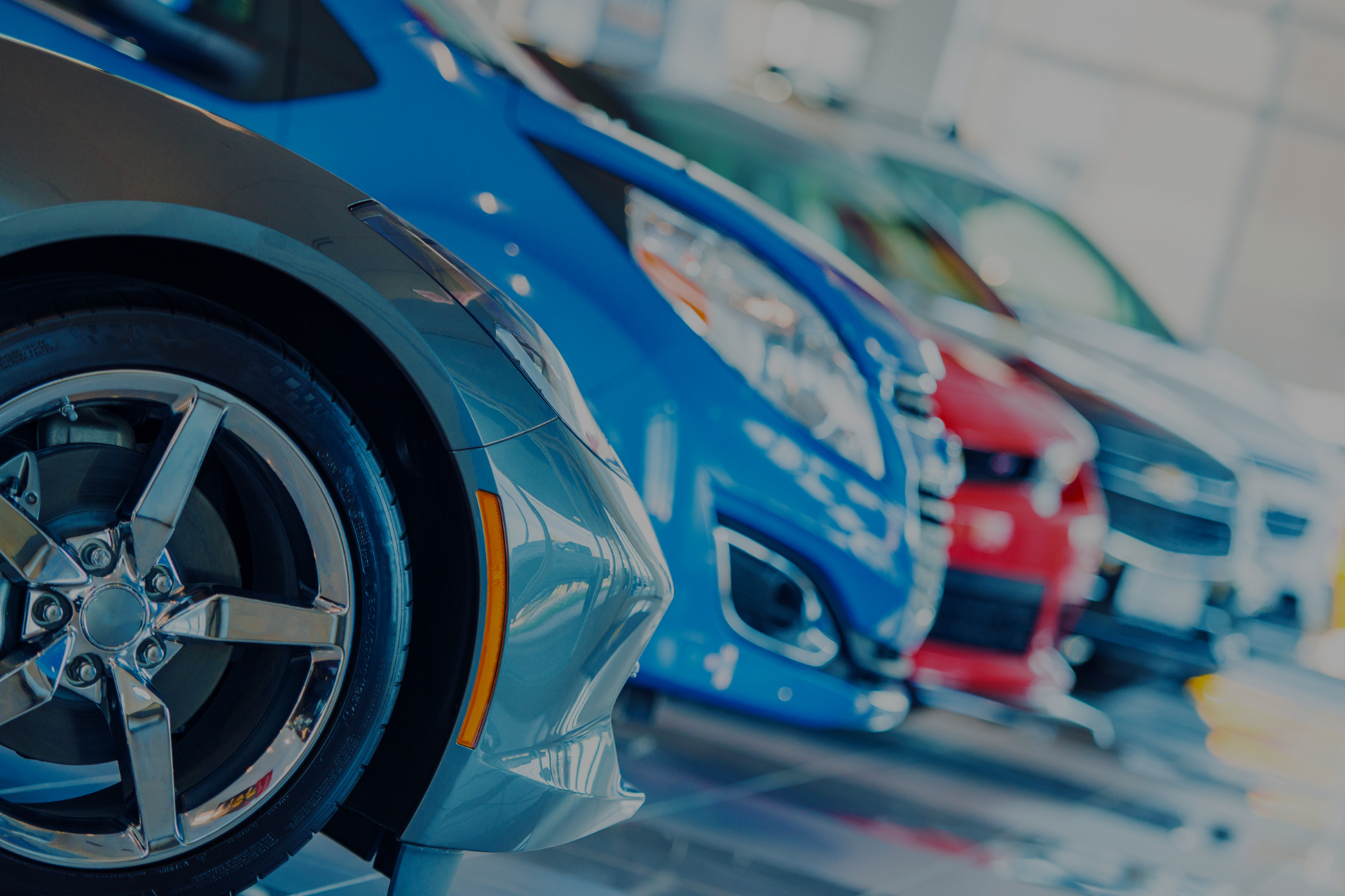 Row of cars on display; blue, silver, red at Car Zone Auto Center 