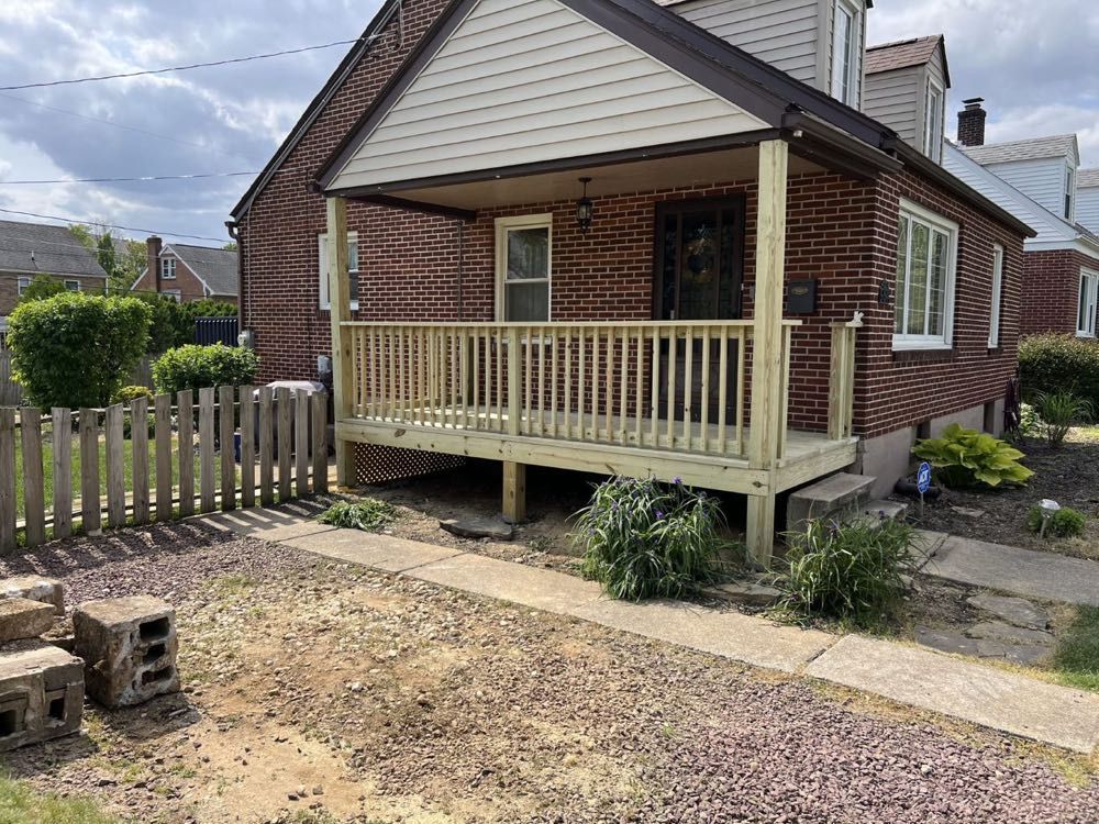 A brick house with a wooden deck in front of it.