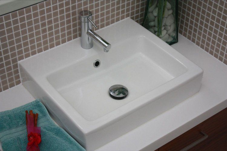 white solid surface bathroom sink with faucet