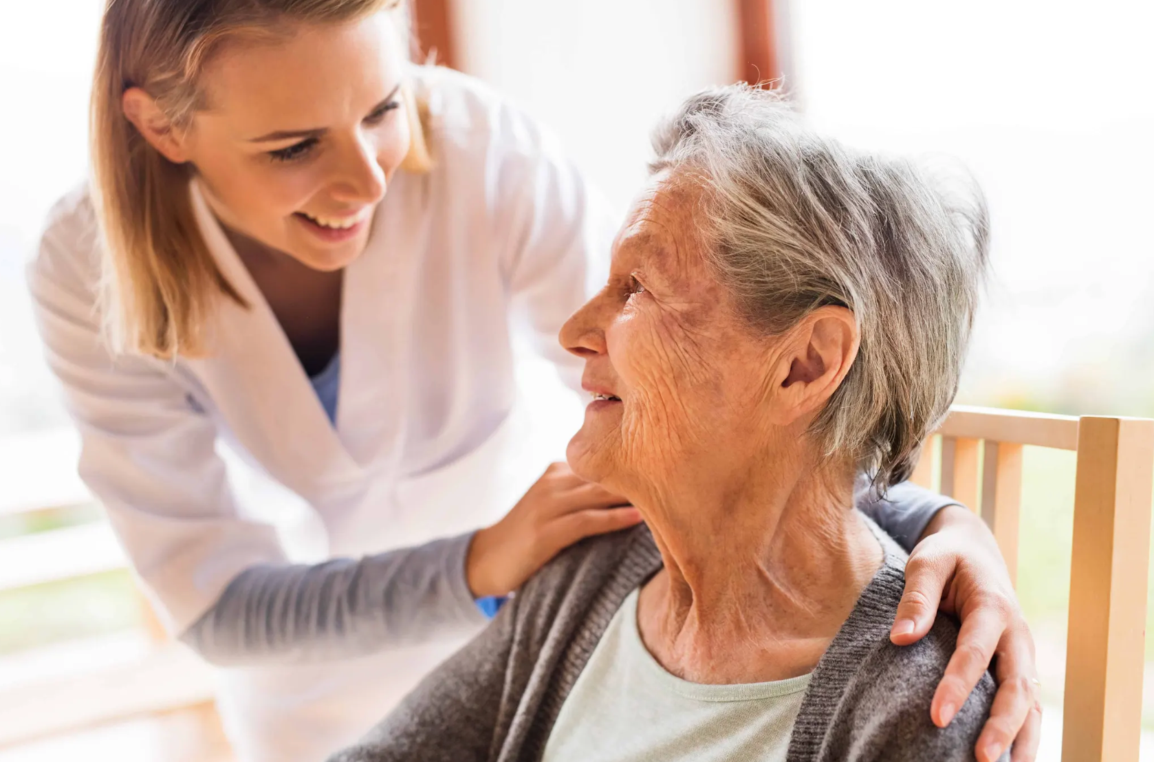 caregiver taking an elderly woman's blood pressure.