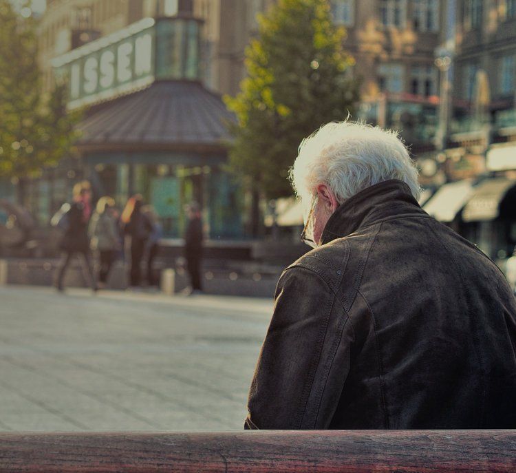 senior man alone on a park bench.