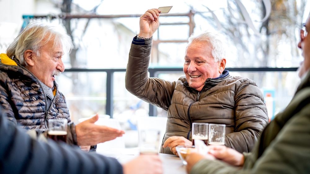 Seniors playing cards in a local bar during winter