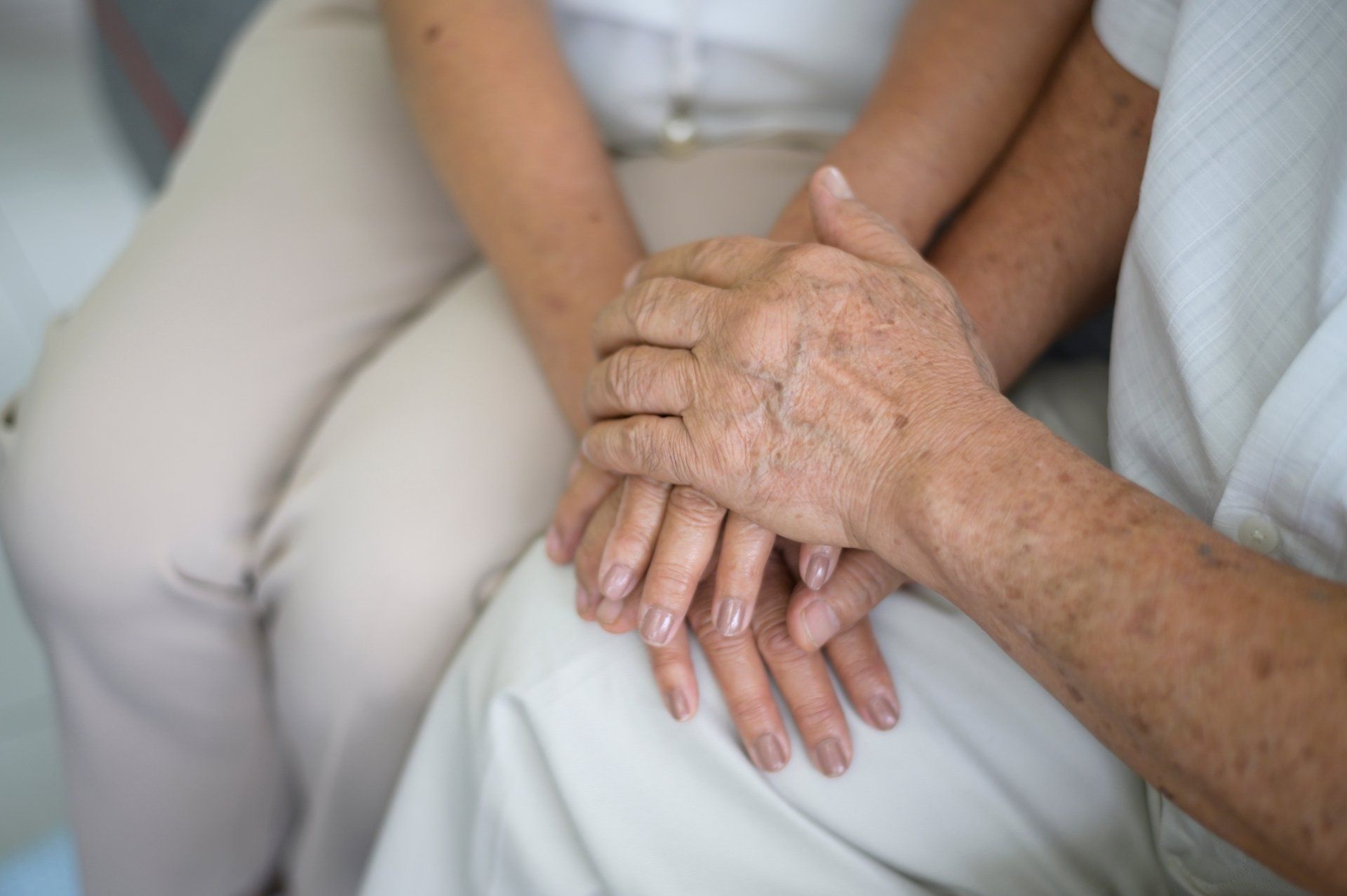 Senior holding hands with caregiver.