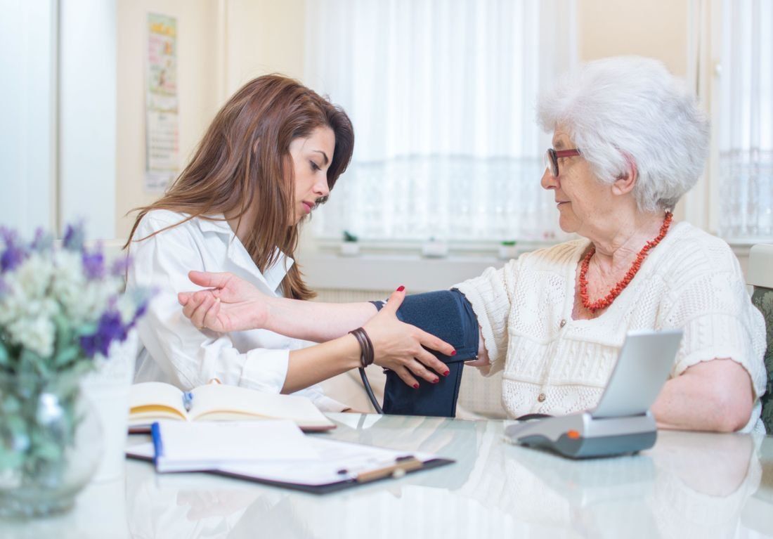 nurse measuring the blood pressure of a female elderly patient.