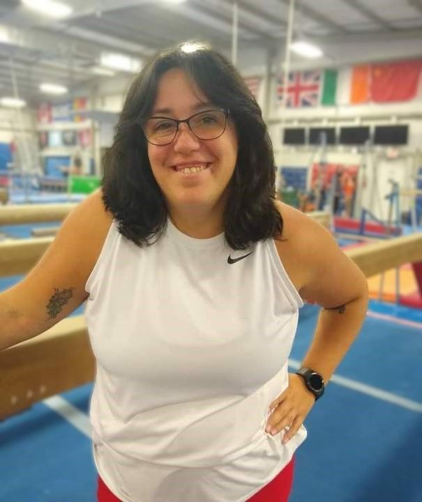 A woman wearing glasses and a white nike tank top