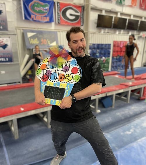 A man holding a sign that says happy birthday