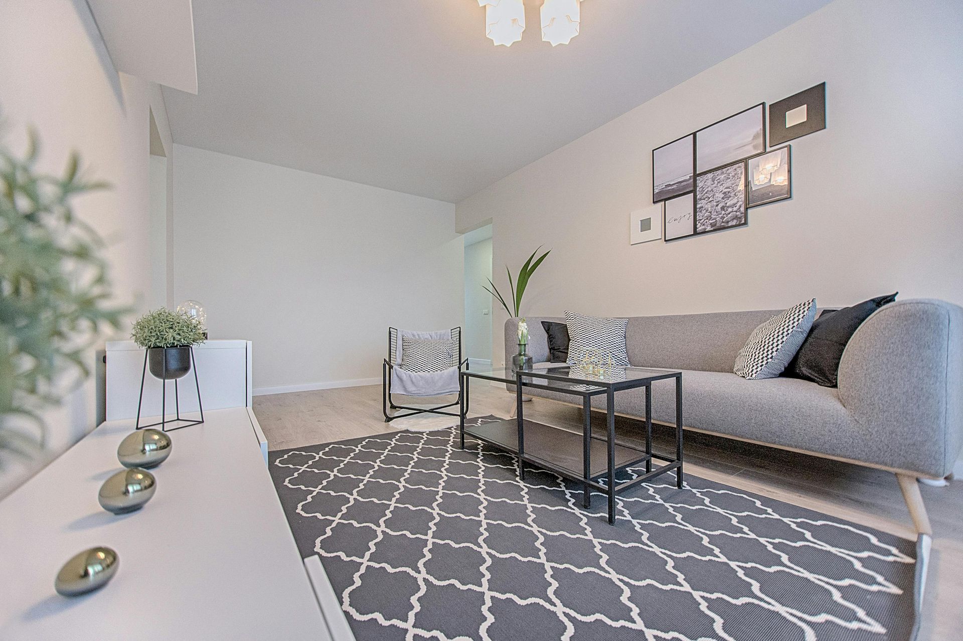 A living room with a couch , chair , table and rug.