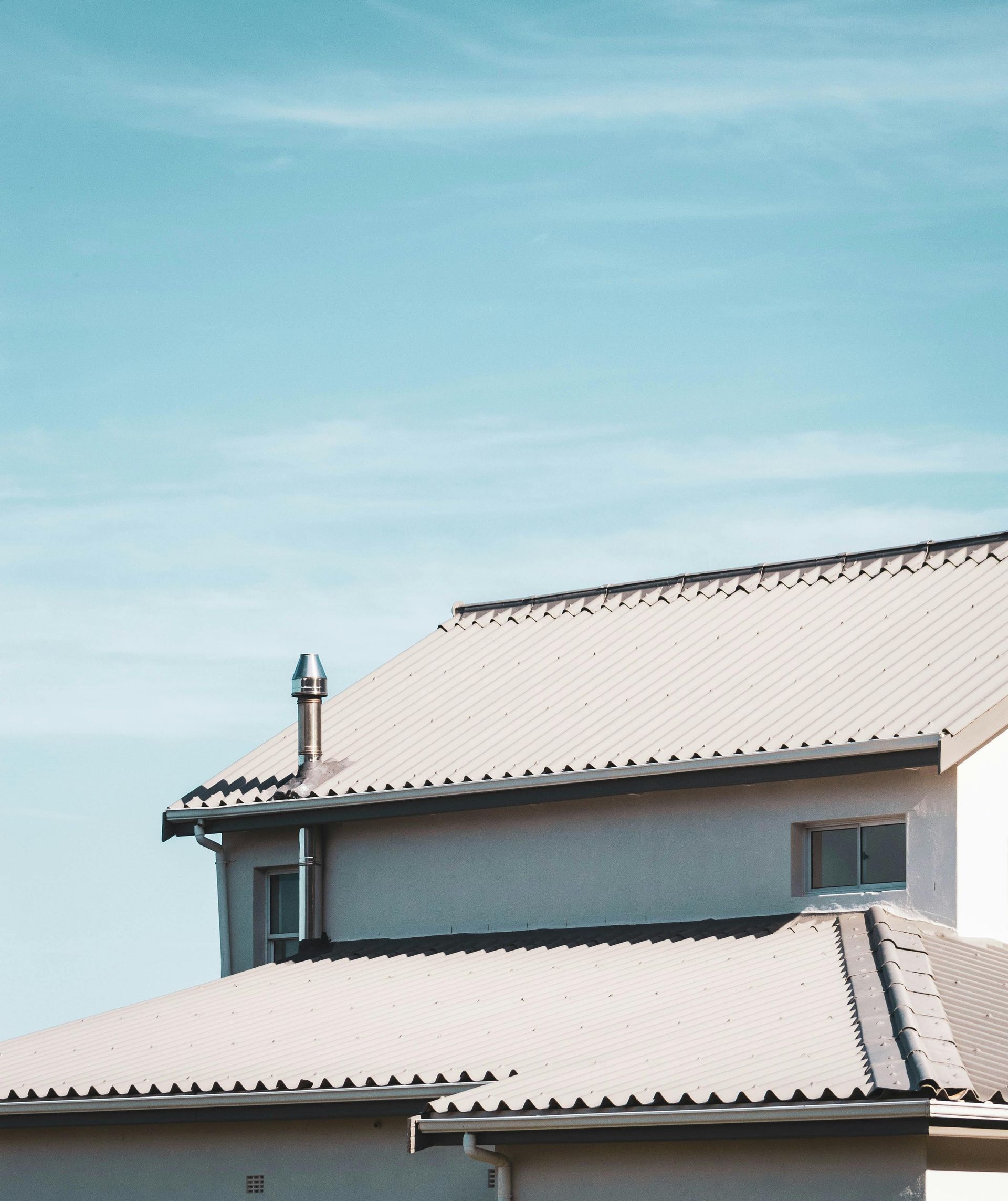 A house with a white roof and a blue sky in the background