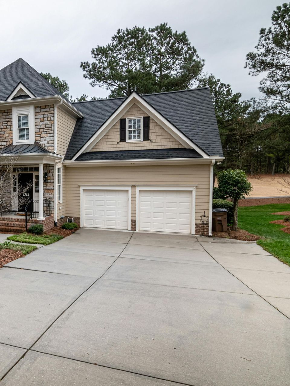 A house with two garage doors and a concrete driveway