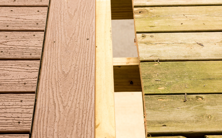 A photo of an old deck that is getting it's wooden boards replaced with composite decking.