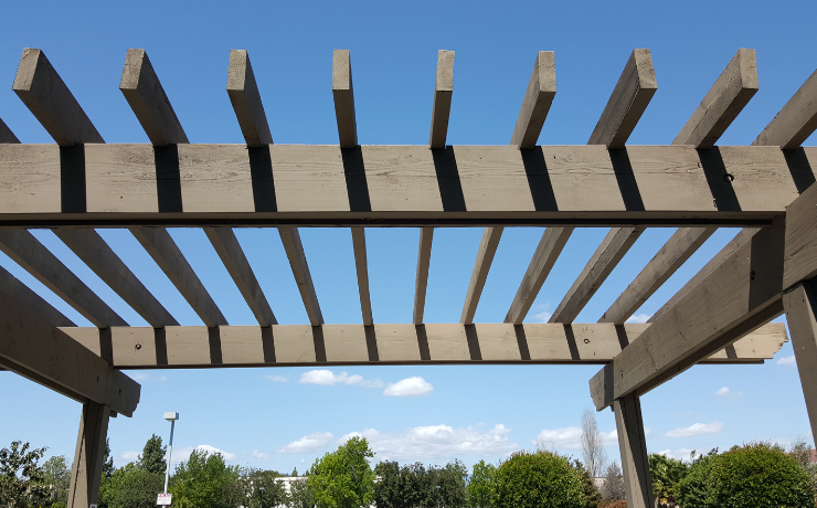 A photo of a pergola sitting in the hot Scottsdale, Arizona sun. The pergola is gray, and no single cloud exists in the sky.