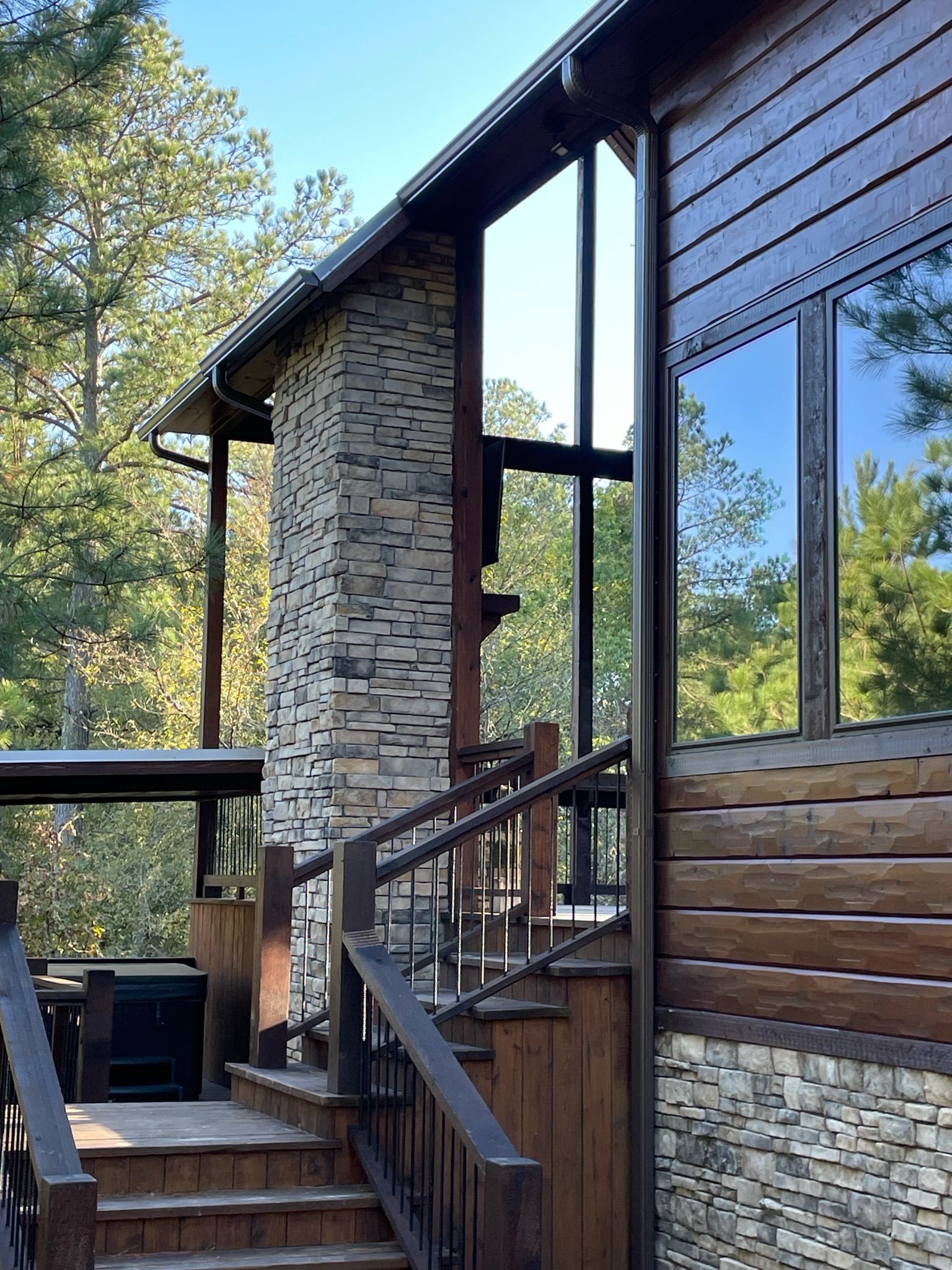 A house with a wooden deck and a wooden fence in front of it.