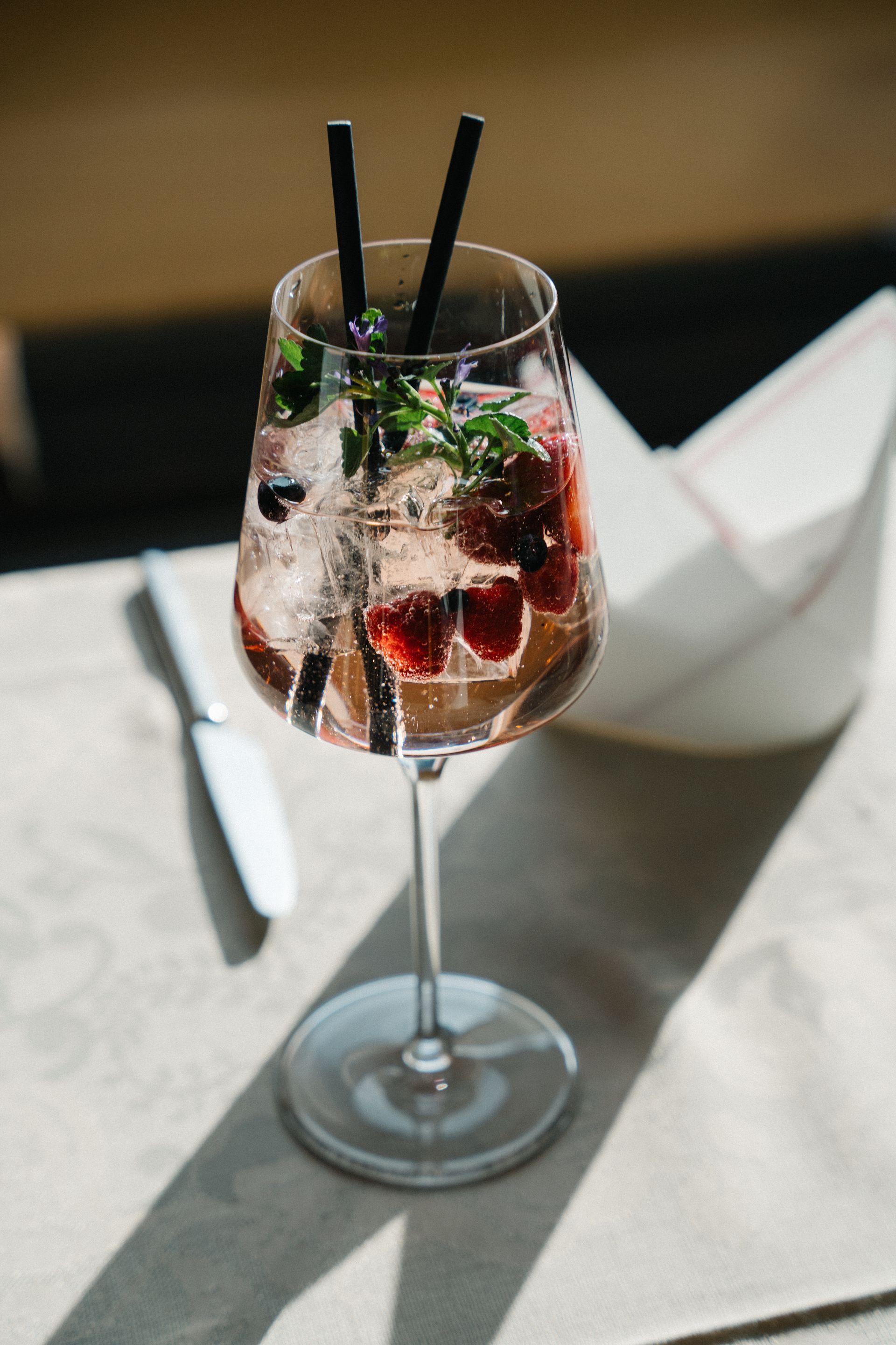 ein Glas Wein mit Erdbeeren und Eis auf einem Tisch.