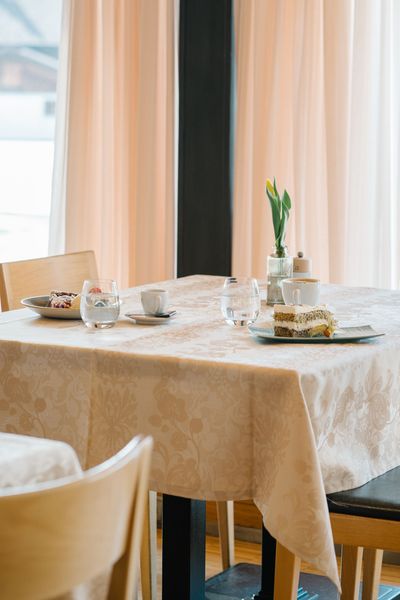 Ein Tisch mit einer weißen Tischdecke und einem Kuchen darauf in einem Restaurant.