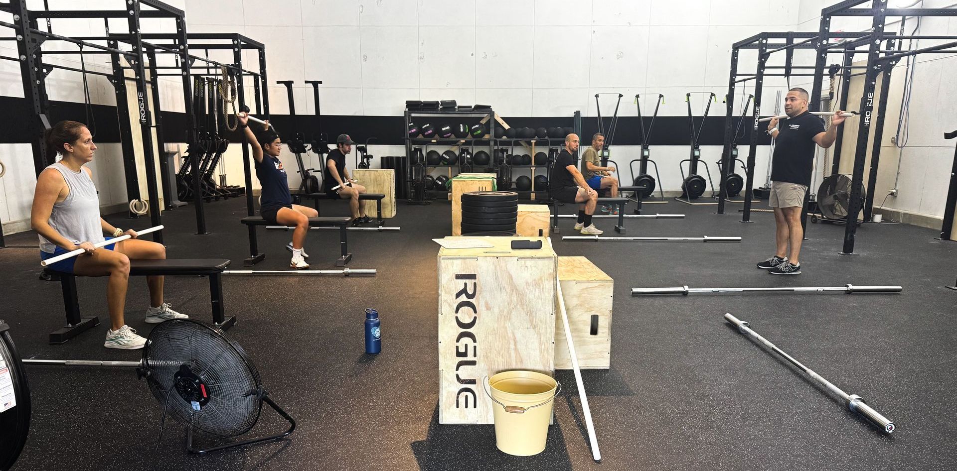 Barbell class at CrossFit Winter Park gym, with athletes practicing Olympic lifts under coach supervision.