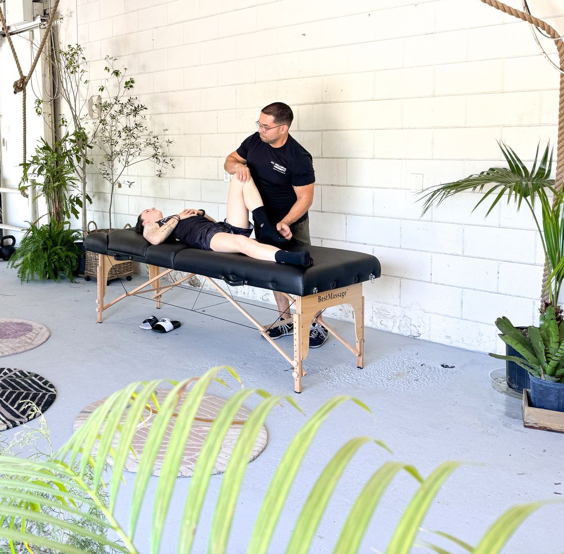 Hands massaging a person's back, likely giving a massage. Close-up shot, warm lighting.
