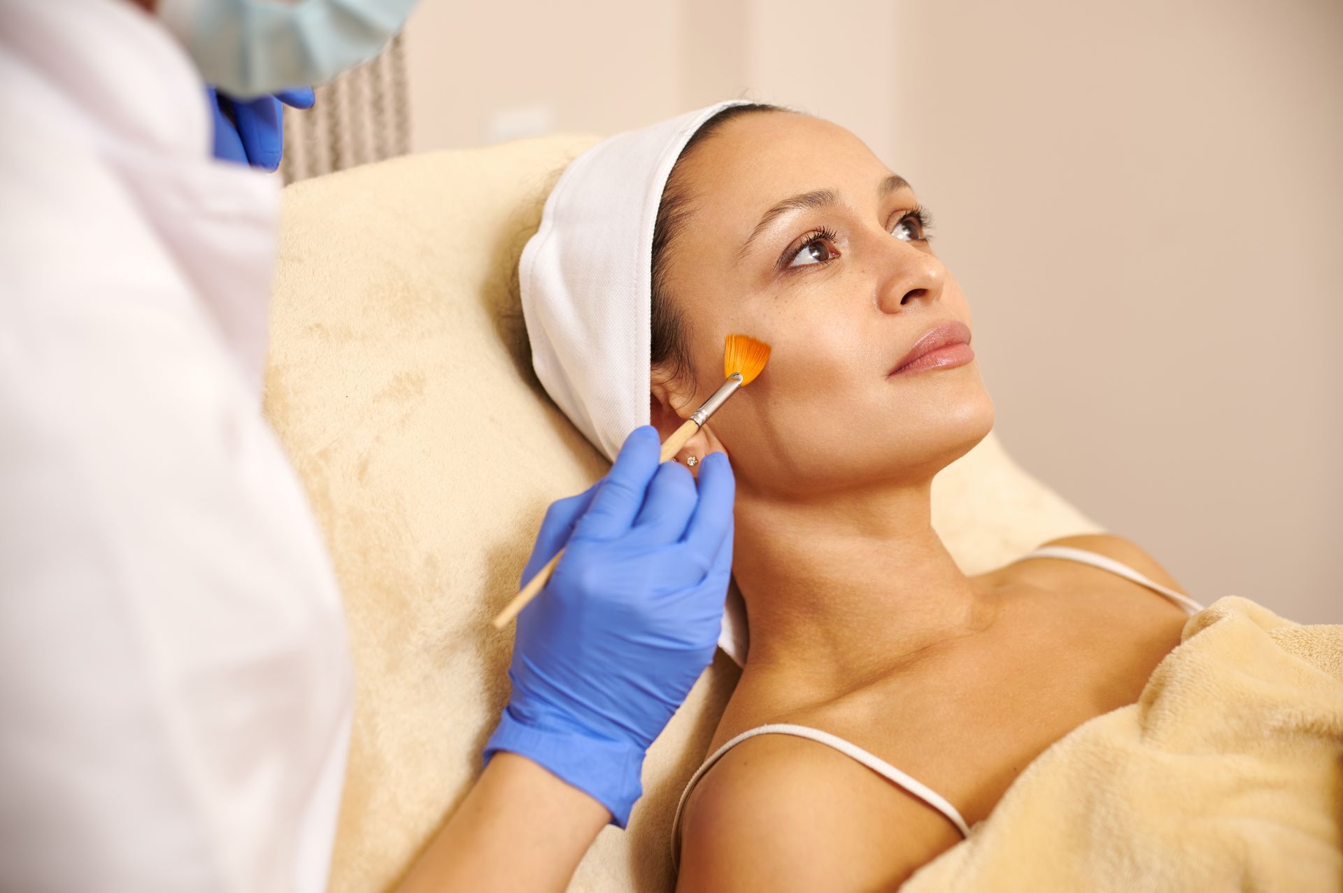 A woman is getting a facial treatment at a beauty salon.