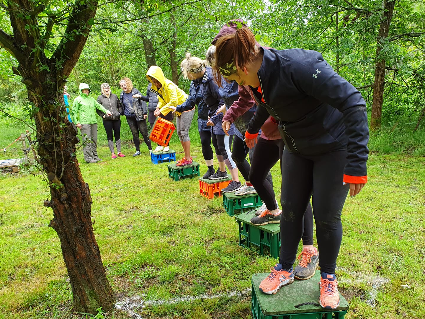 A group of people are standing on crates in a field.
