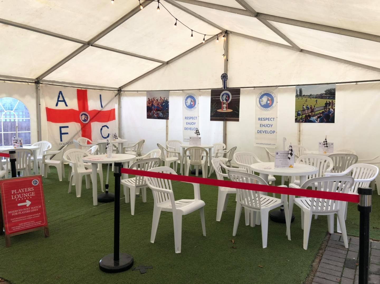 A white tent with tables and chairs inside of it