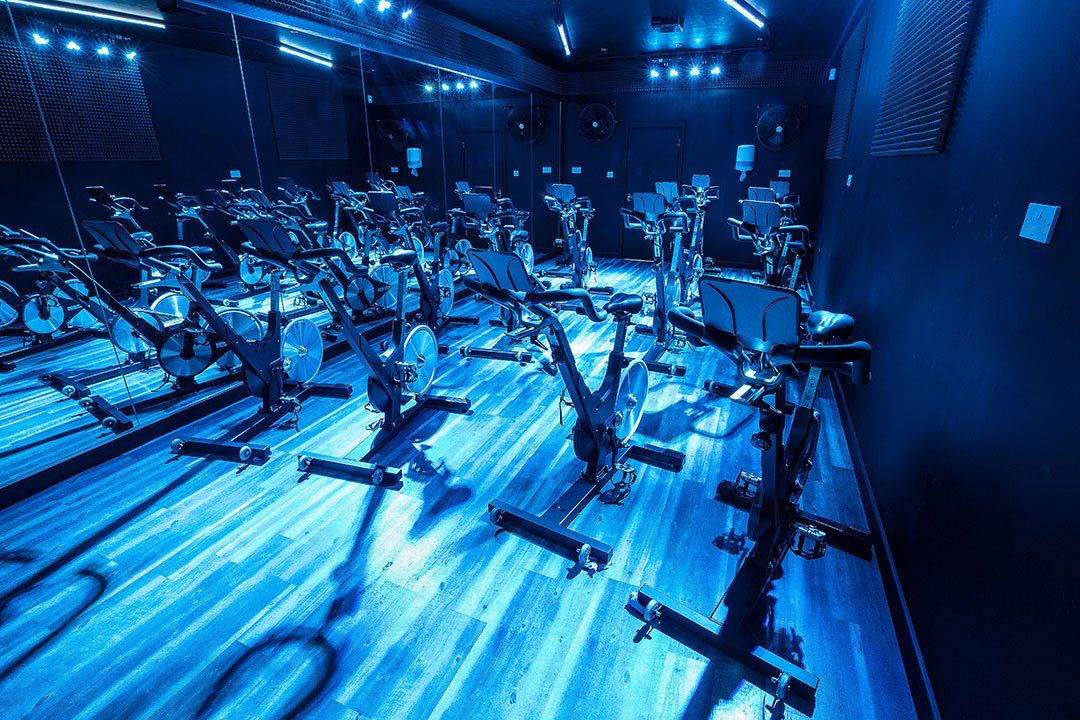 A gym with a lot of exercise bikes on the floor.