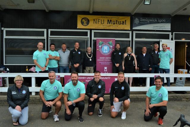 A group of people posing in front of a building that says nfu mutual