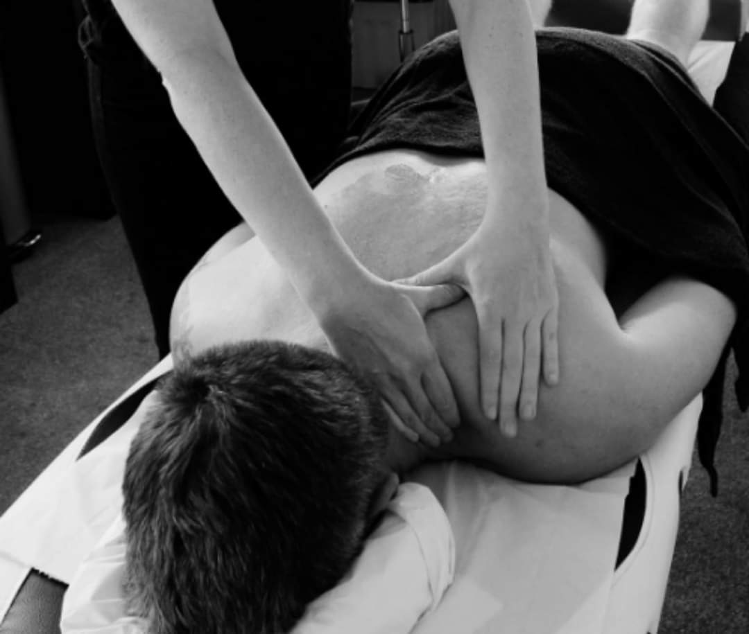 A black and white photo of a man getting a massage