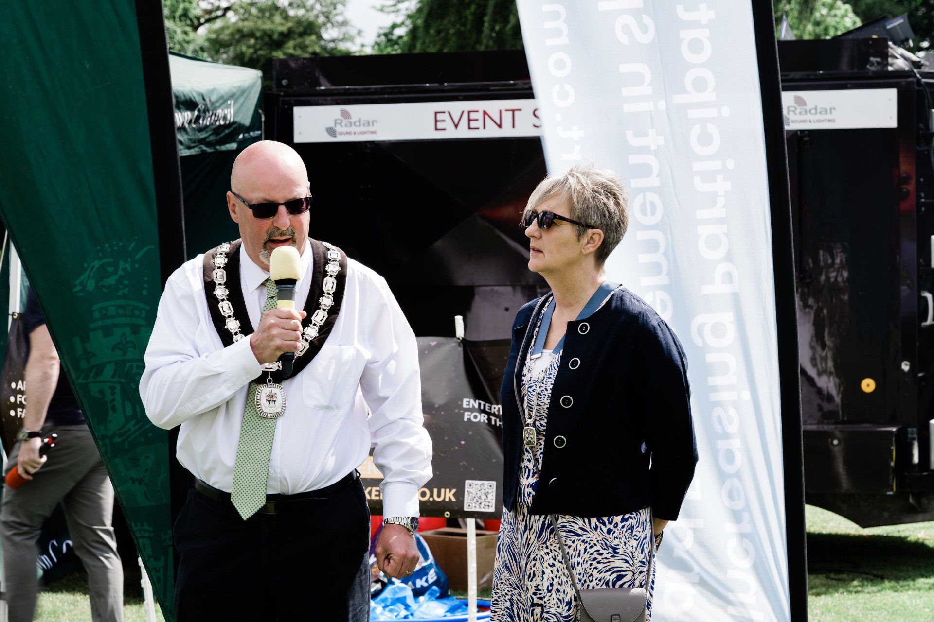 A man speaking into a microphone next to a woman