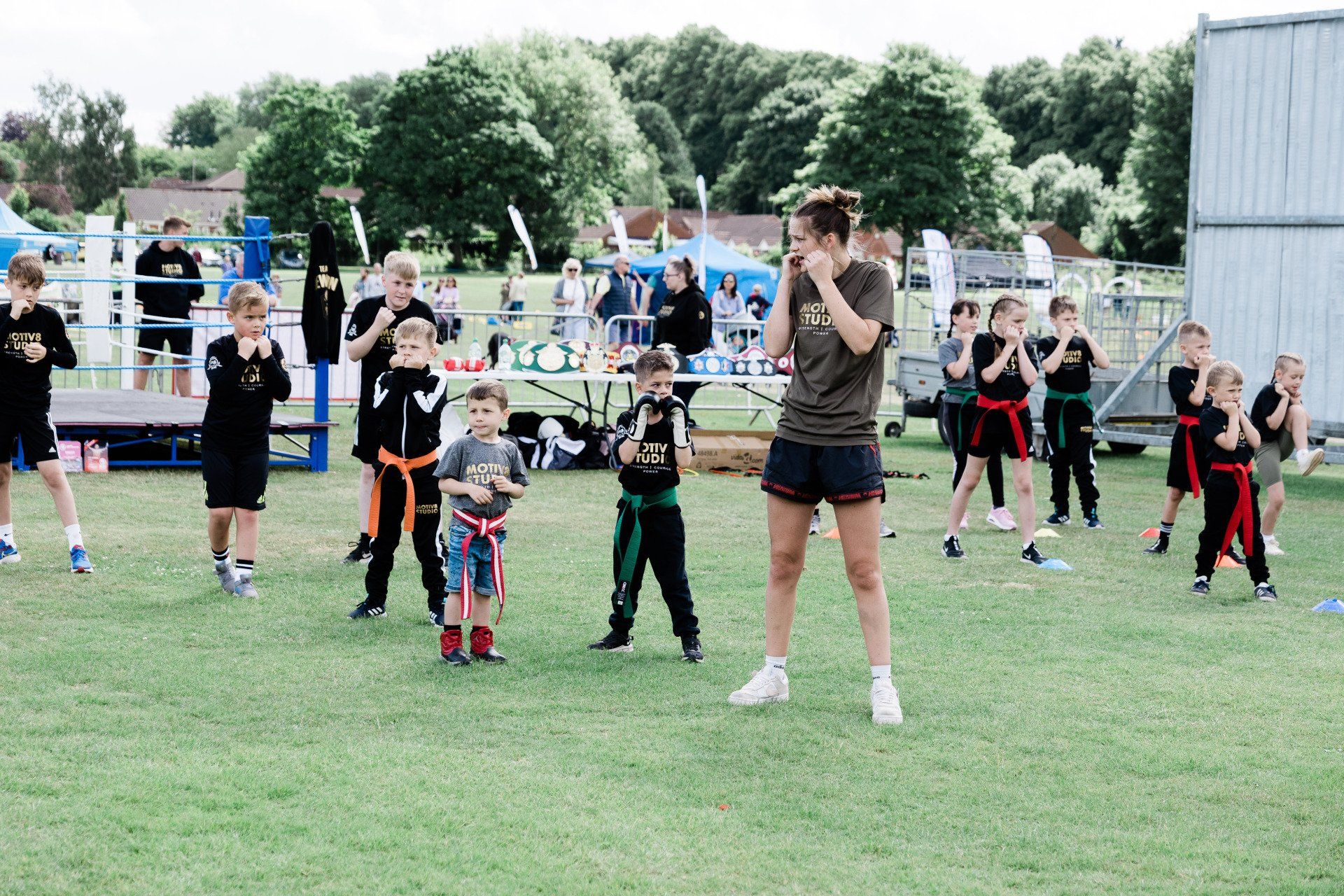 A group of children are practicing martial arts in a field.