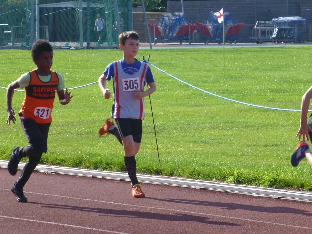 A boy with the number 505 on his shirt is running on a track