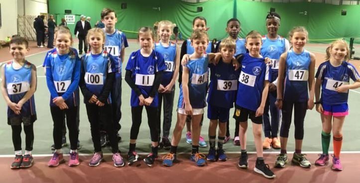 A group of children are posing for a picture in a gym.