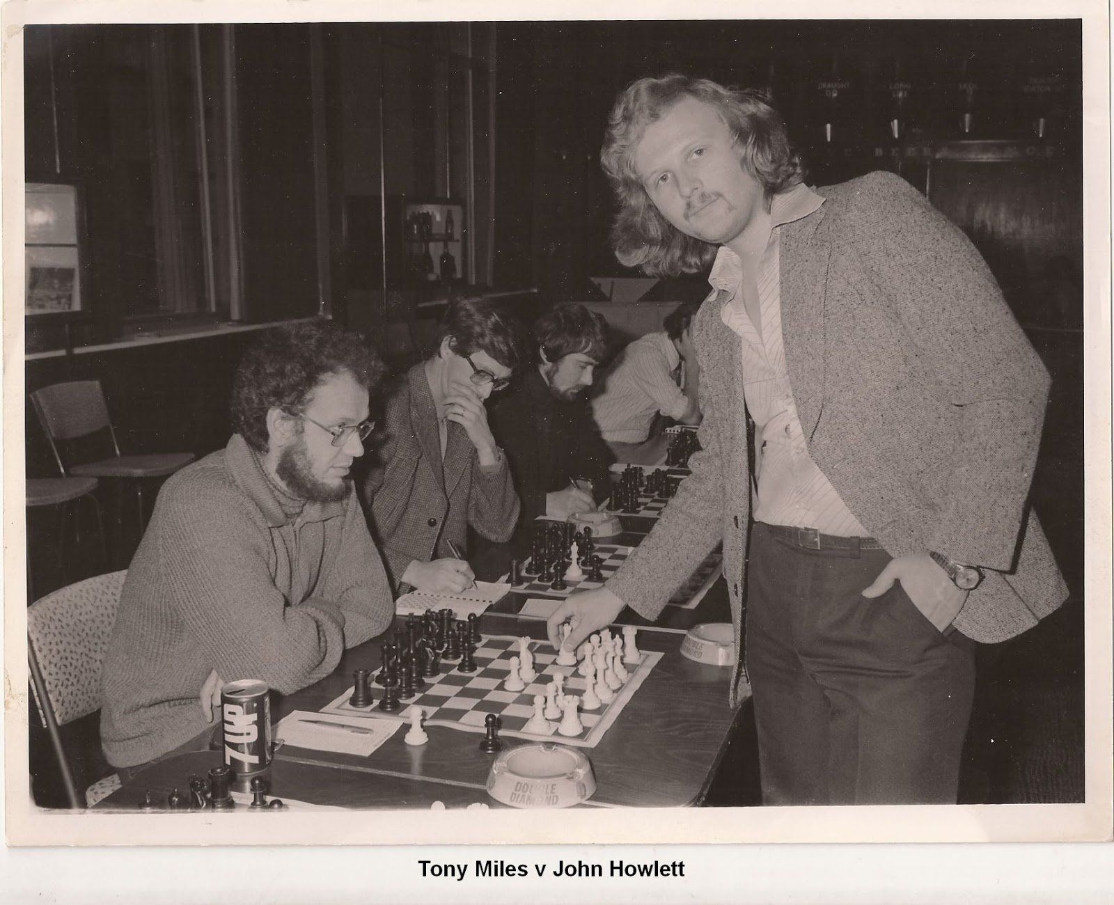 A black and white photo of a group of men playing chess