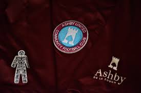 A close up of a maroon shirt with a logo on it.