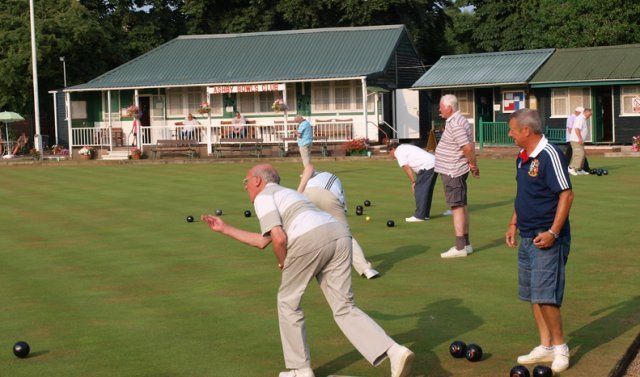 A group of men are playing a game of bowling