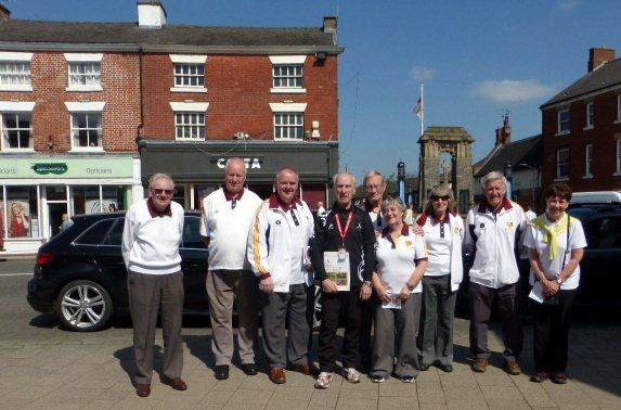 A group of people standing in front of a building that says costa