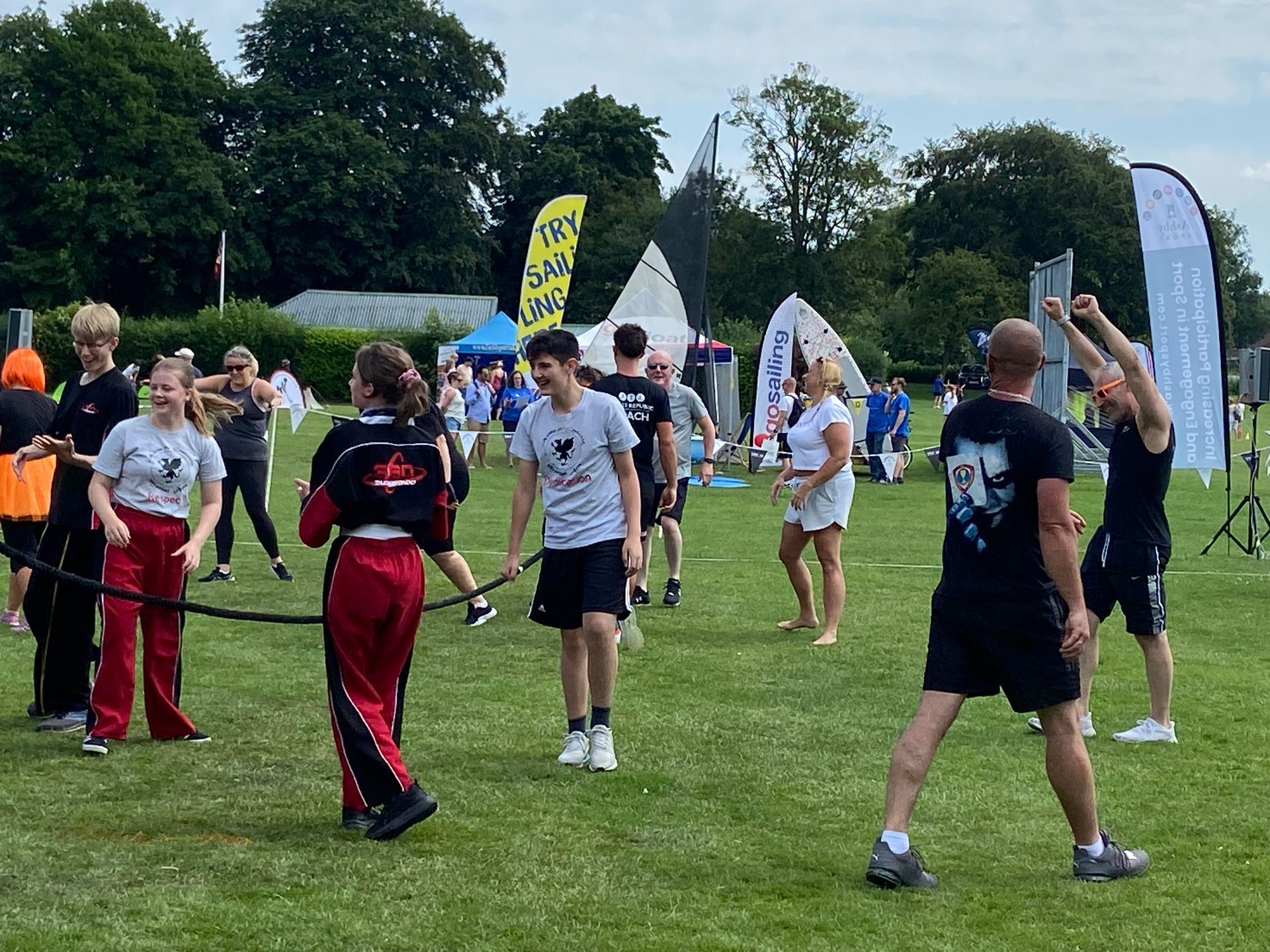 A group of people are standing on top of a lush green field.