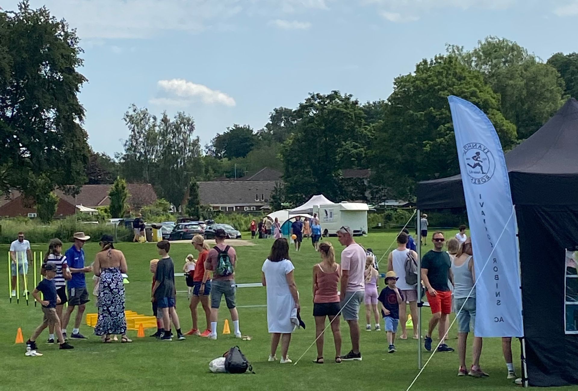 A group of people are standing in a field with a flag that says ' a ' on it