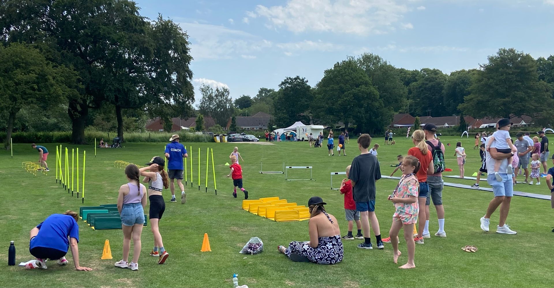 A group of people are playing in a park on a sunny day.