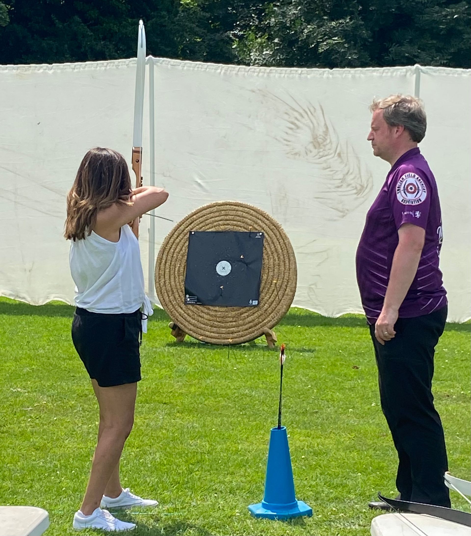 A man and a woman are standing in front of a target.