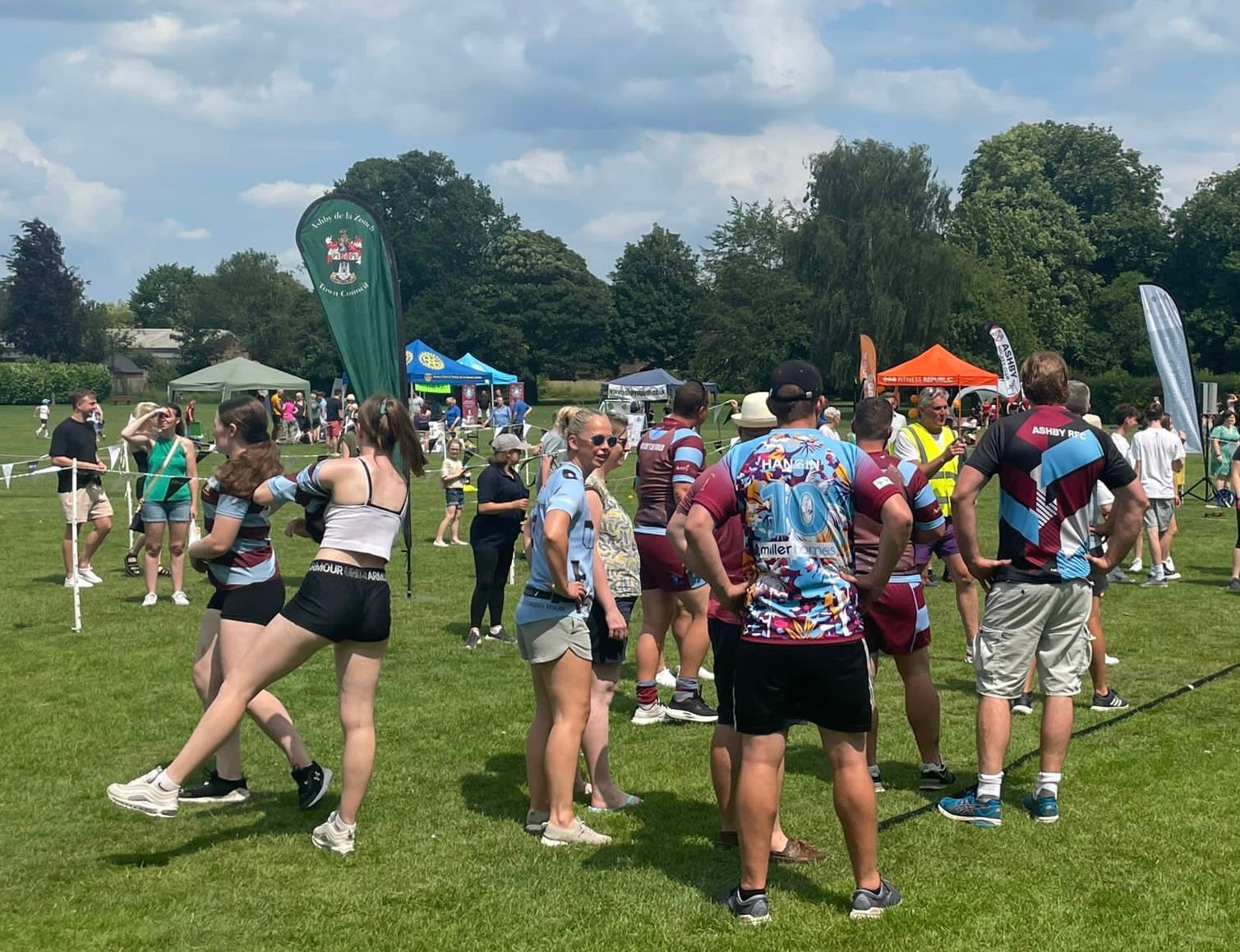 A group of people are standing in a grassy field.