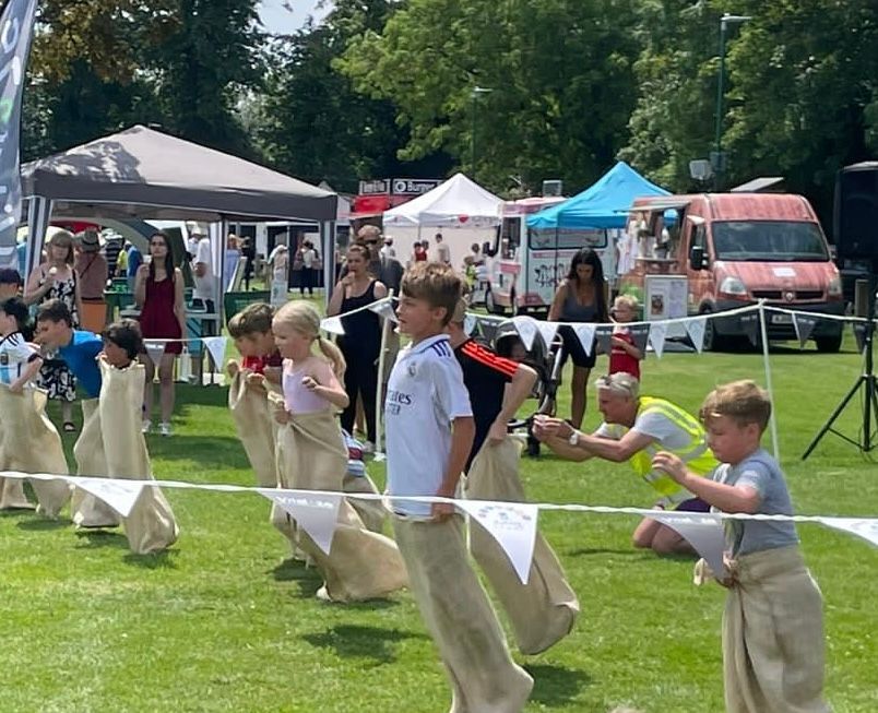 A group of children are playing sack race in a field