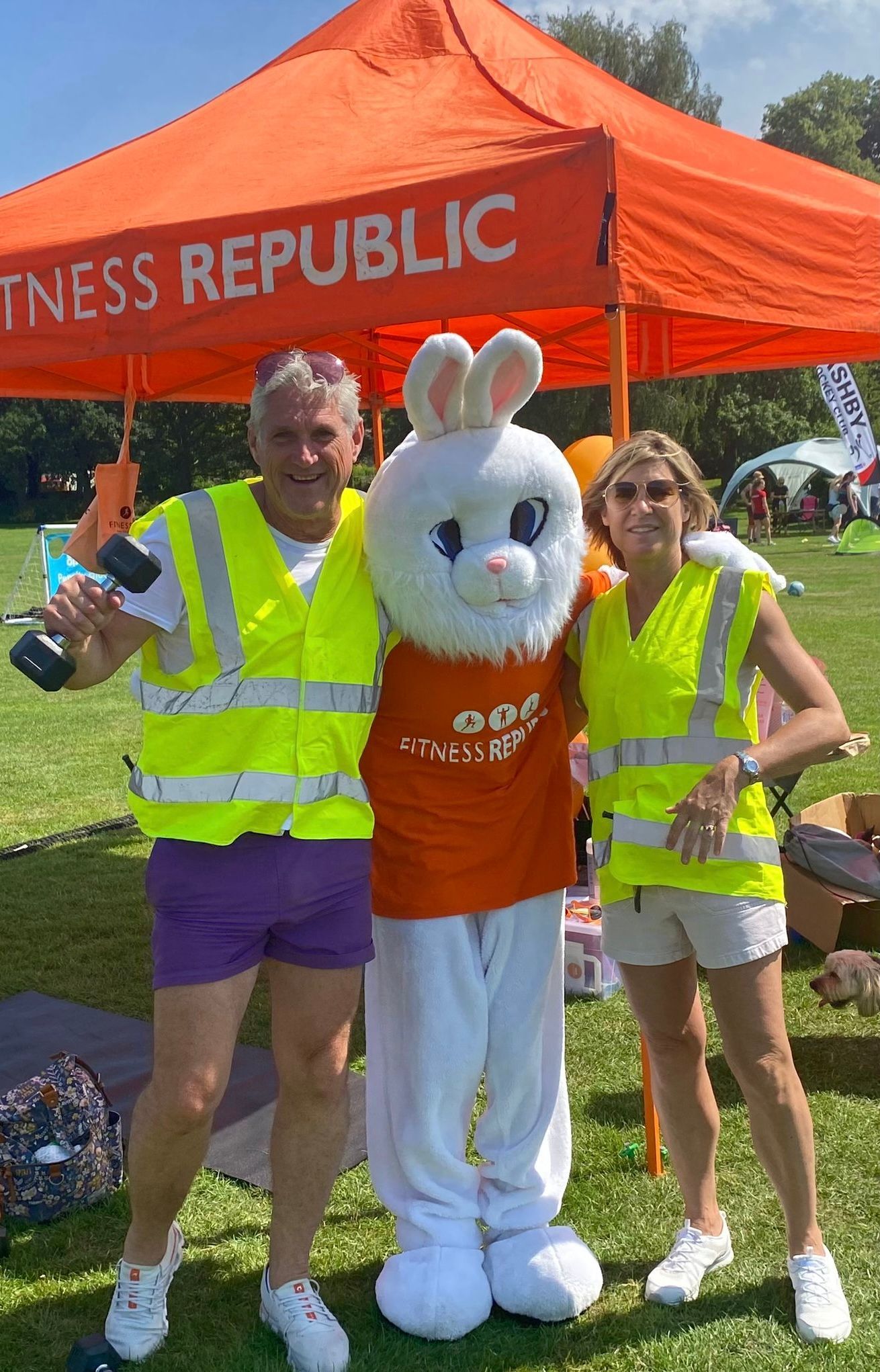 A man and two women are posing for a picture with a bunny mascot.