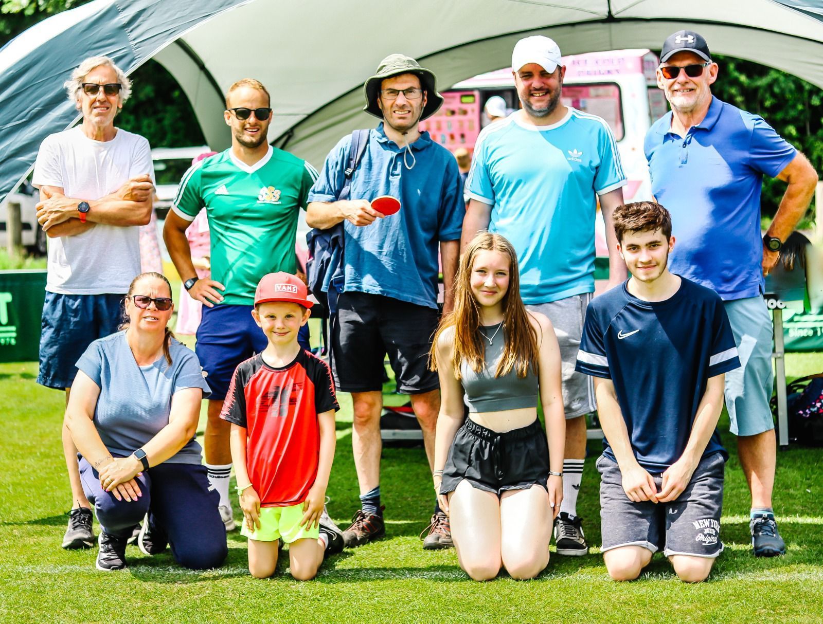 A group of people are posing for a picture on a field.