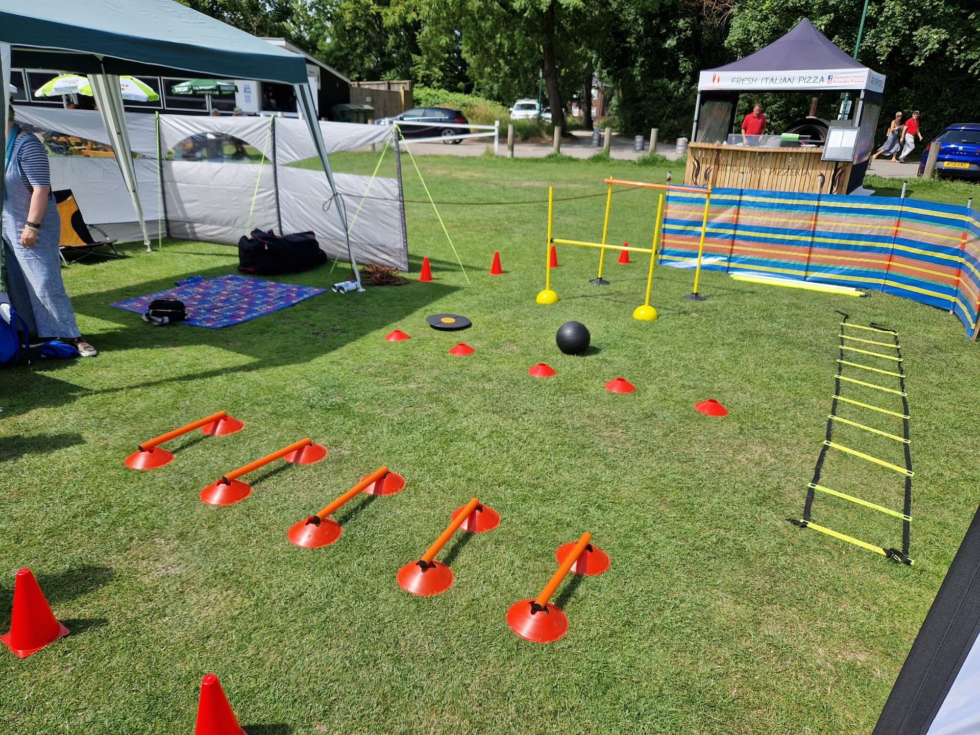 A lawn with a bunch of cones and a ladder on it