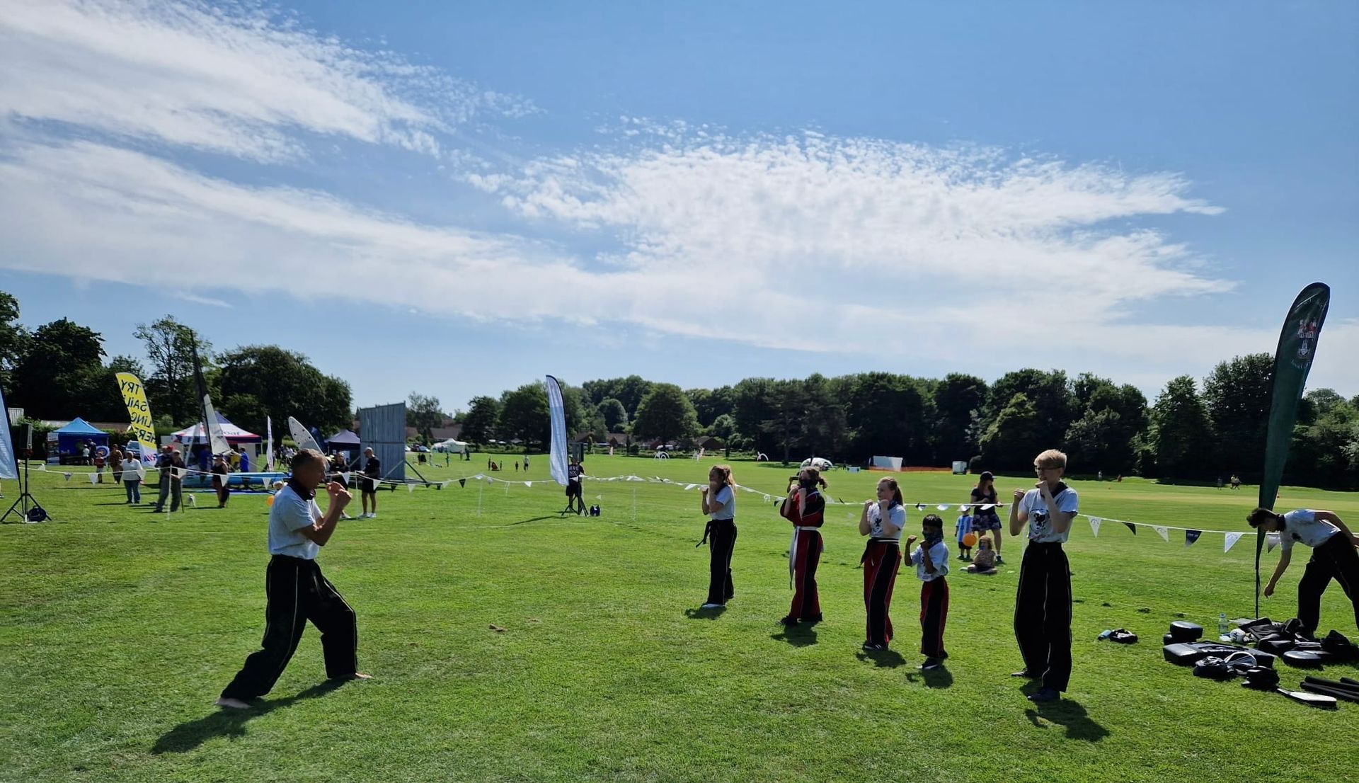 A group of people are standing in a grassy field.
