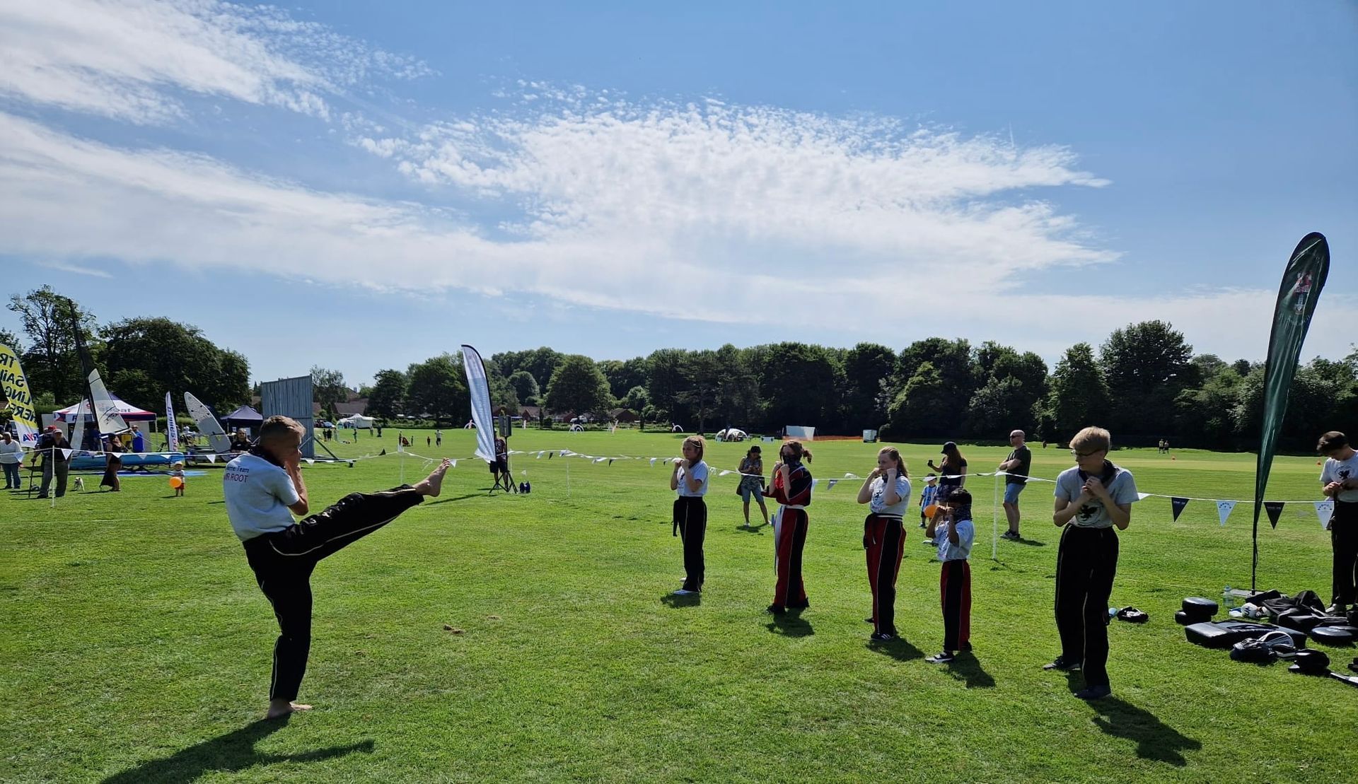 A group of people are standing in a grassy field.