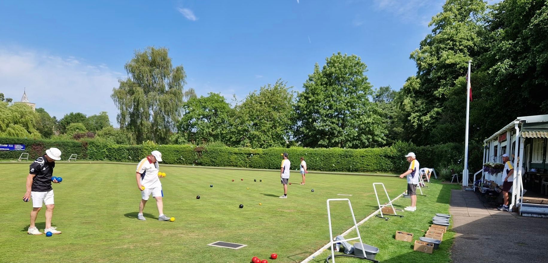 A group of people are playing a game of croquet on a lush green field.