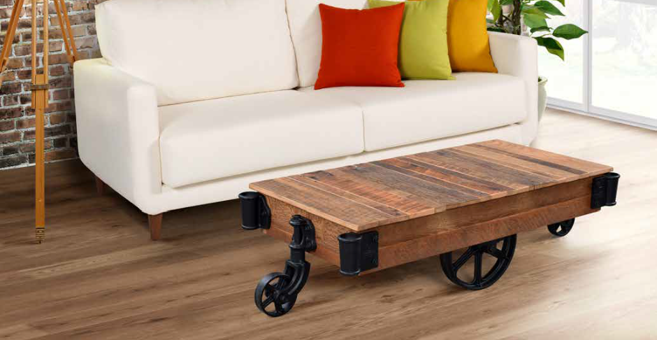 A living room with a white couch and a wooden coffee table with wheels.