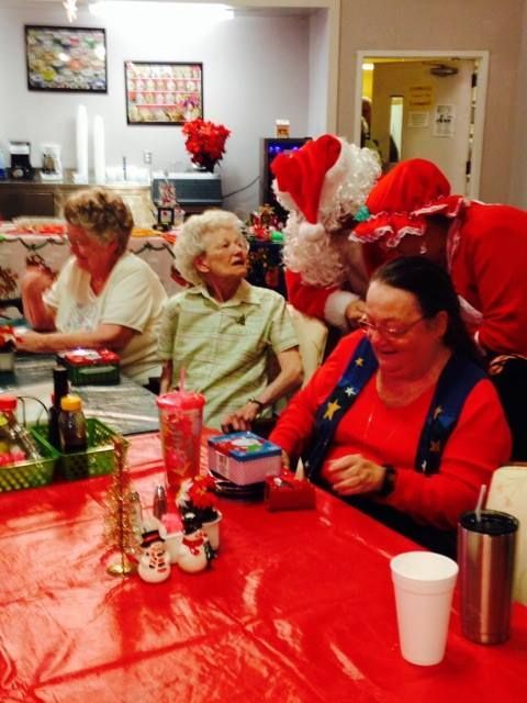 A group of people sitting at a table with santa claus