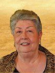 An older woman is smiling for the camera while wearing a leopard print jacket.