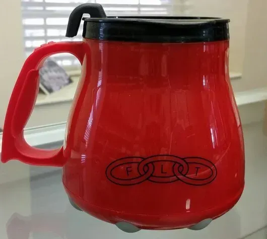 A red mug with the word audi on it